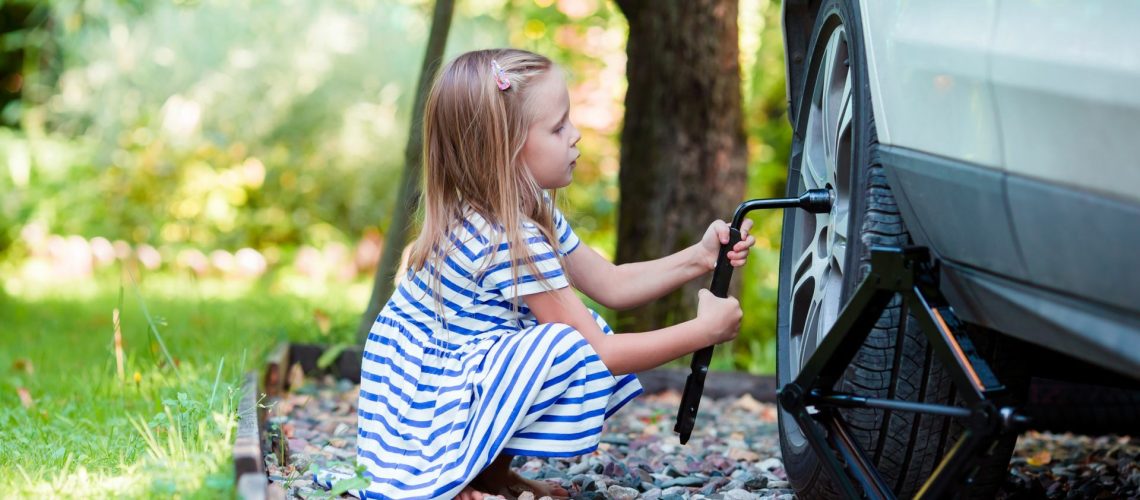 Technische Berufe für Mädchen - ein kleines Mädchen versucht, einen Reifen zu schrauben